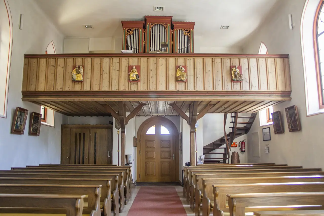 Kircheninnenraum mit Empore und der von Schreinerei Knorz gefertigten Eingangstür